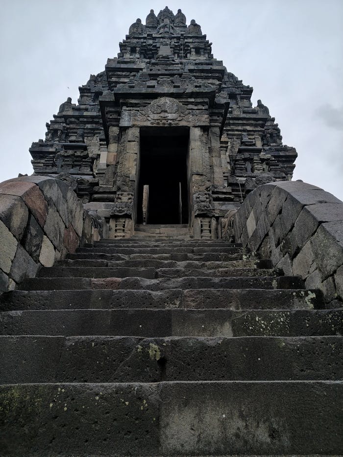 Majestic ancient temple with stone steps leading to Prambanan entrance.